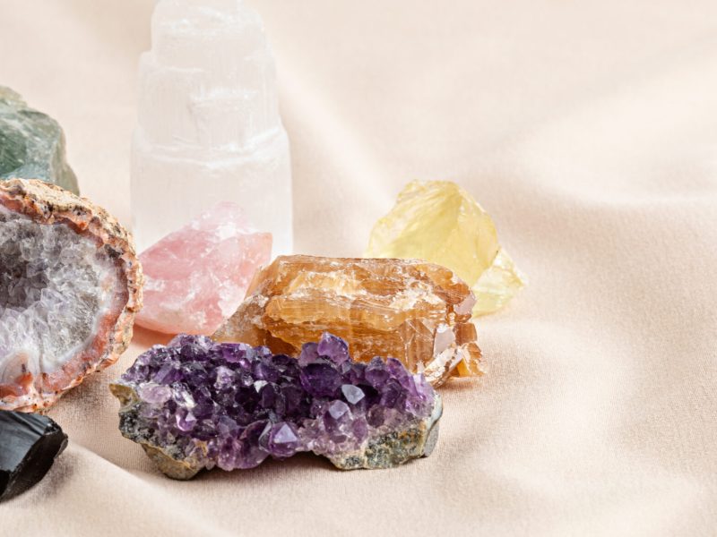 Healing reiki chakra crystals over fabric background. Gemstones for wellbeing, harmony, meditation, relaxation, metaphysical, spiritual practices. Energetical power concept